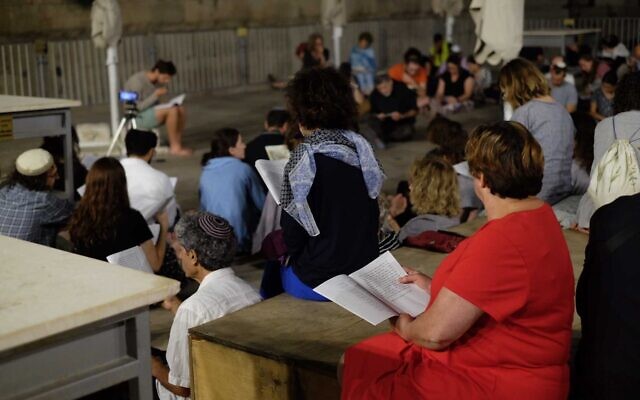 Des personnes se rassemblent pour écouter une lecture du Livre des Lamentations à la section égalitaire du mur Occidental, le 6 août 2022. (Crédit : Judah Ari Gross/Times of Israel)