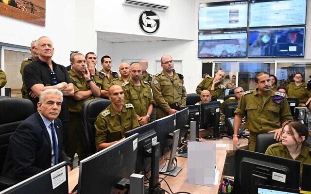Le Premier ministre Yair Lapid, à gauche, et le ministre de la Défense Benny Gantz, 2ème à gauche, en visite du Commandement du Sud, lors des combats dans la bande de Gaza entre Israël et le groupe terroriste palestinien du Jihad islamique, le 7 août 2022. (Crédit : Haim Zach/GPO)