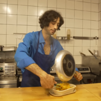 Tal Rachevski, le propriétaire de Tometomato open/closed prépare un plat de pâtes, dans un documentaire publié par la chaîne publique Kan le 9 août 2022. (Crédit : Capture d'écran)