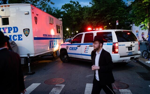Illustration : Des véhicules de police et de sécurité communautaire lors d'un événement juif à Brooklyn, à New York, le 19 mai 2022. (Crédit : Luke Tress/Times of Israel)