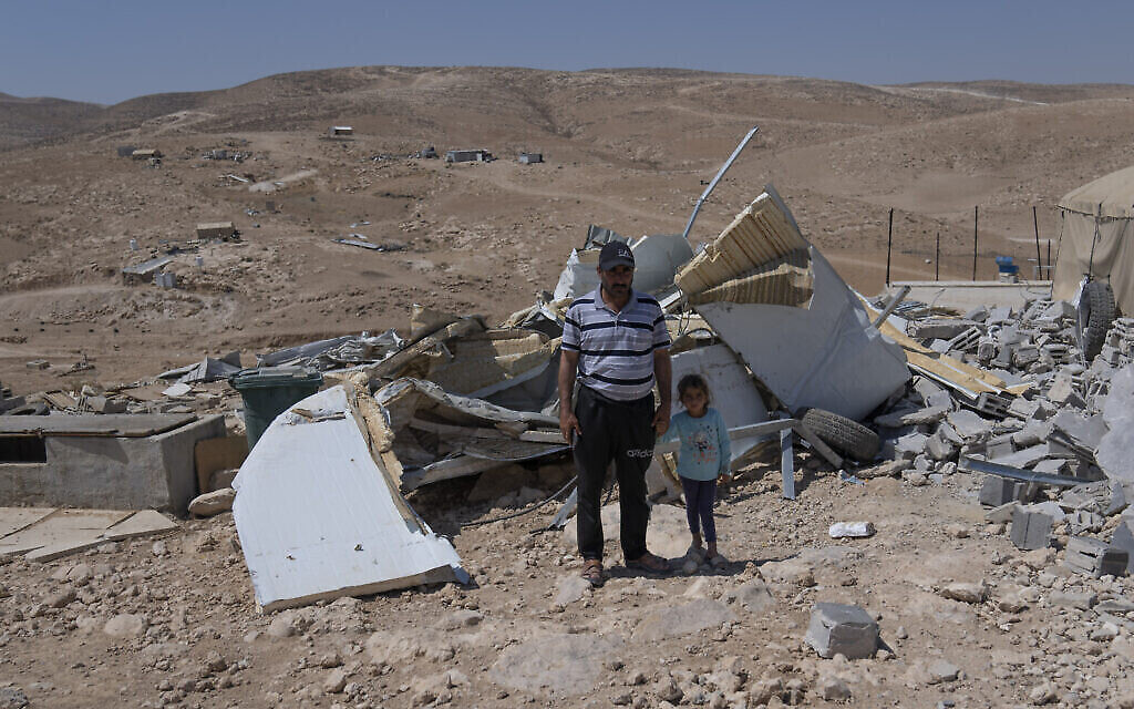 Mohammed Abu Sabaha, 46 ans, et sa fille Zeynab posent parmi les ruines de la maison familiale démolie par l’armée israélienne, dans le hameau palestinien d’al-Fakhit à Masafer Yatta, en Cisjordanie, 1er lundi août 2022. (AP/Nasser Nasser)