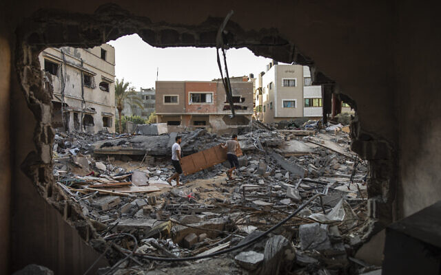 Des Palestiniens inspectent leur maison qui a été touchée par une frappe aérienne israélienne dans la ville de Gaza, lundi 8 août 2022. (Crédit : AP Photo/Fatima Shbair)