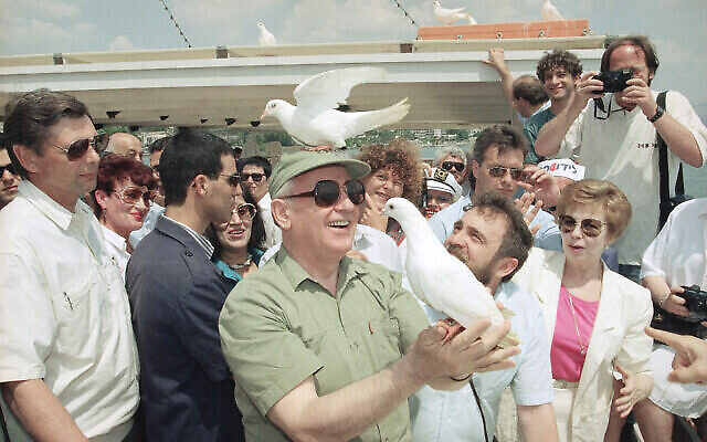 Une colombe de la paix se perche sur la tête de l’ex-président soviétique Mikhaïl Gorbatchev, le lundi 15 juin 1992, alors qu’il libère un autre oiseau lors d’un voyage d'agrément sur le lac de Tibériade, en Israël. (Crédit : AP Photo/Jerome Delay)