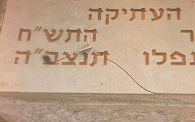 Une pierre tombale dans la section militaire du cimetière du Mont des Oliviers qui a été vandalisée avec des graffitis, le 16 août 2022. (Crédit : Police israélienne)