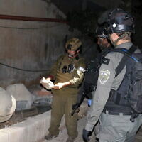 Des soldats israéliens examinant des antiquités volées récupérées lors d'une opération d'arrestation en Cisjordanie, le 15 août 2022. (Crédit : Coordinateur des activités gouvernementales dans les territoires)