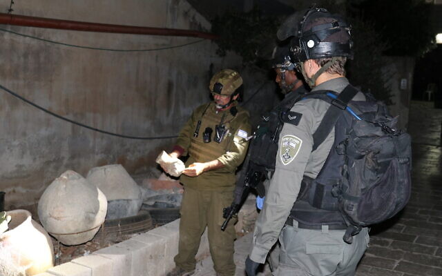 Des soldats israéliens examinant des antiquités volées récupérées lors d'une opération d'arrestation en Cisjordanie, le 15 août 2022. (Crédit : Coordinateur des activités gouvernementales dans les territoires)