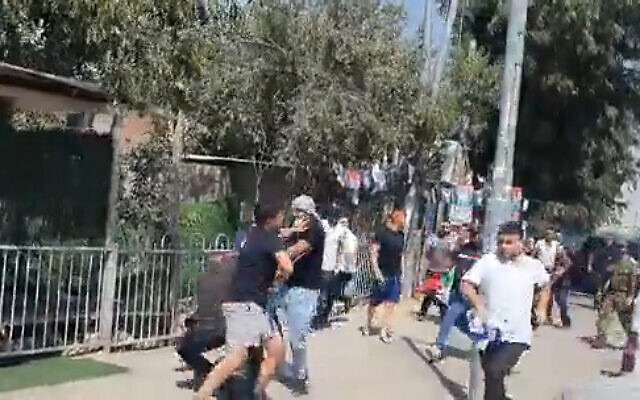 Un homme transportant un drapeau israélien agressé par un groupe de manifestants brandissant le drapeau israélien près du tombeau de  Samuel, aux abords de Jérusalem, le 26 août 2022. (Capture d'écran: Twitter)