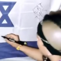 Un membre du groupe de hip-hop espagnol Tribade vandalisant un drapeau israélien lors du festival de musique Sziget, en Hongrie, le 14 août 2022. (Crédit : Instagram)