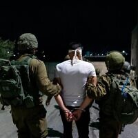 Les forces de sécurité israéliennes arrêtent un suspect terroriste en Cisjordanie, le 6 août 2022. L'armée a déclaré avoir arrêté 20 Palestiniens, dont 19 affiliés au Jihad islamique palestinien dans des villes et villages de Cisjordanie. (Crédit : armée)