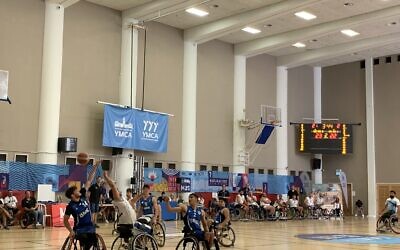 Les équipes israélienne et américaine de basket-ball en fauteuil roulant s'affrontent lors du match final des Maccabiades au YMCA international de Jérusalem, le 21 juillet 2022. (Crédit : Charlie Summers/Times of Israel)