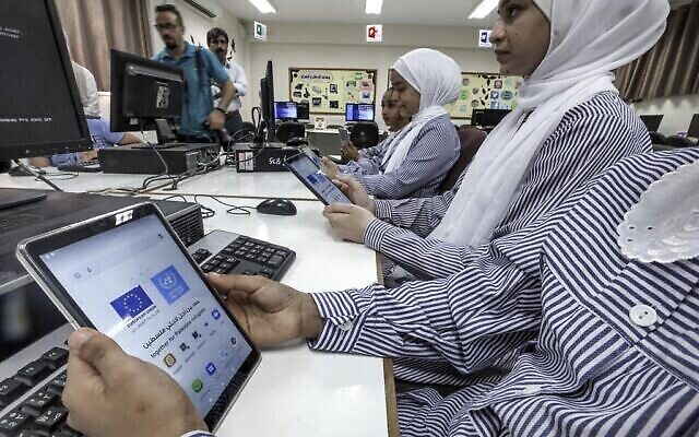 Les élèves d'une école gérée par l'Office de secours et de travaux des Nations Unies pour les réfugiés de Palestine (UNRWA) utilisent de nouvelles tablettes électroniques en classe, dans la ville de Gaza, le 7 septembre 2022 (Crédit : MOHAMMED ABED / AFP)