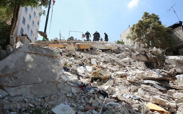 Les équipes de secours jordaniennes recherchent 10 personnes portées disparues sous les décombres d'un immeuble de quatre étages qui s'est effondré dans la capitale Amman, le 14 septembre 2022, un jour après que cinq corps y aient été retrouvés. (Crédit : Khalil MAZRAAWI / AFP)