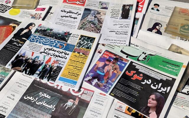 Un kiosque dans la capitale iranienne, le 18 septembre 2022, avec en première page des articles et des photographies de Mahsa Amini, une femme de 22 ans morte après avoir été arrêtée par la "police de la moralité" de la République islamique il y a deux jours. (Crédit : ATTA KENARE / AFP)