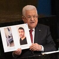 Le chef de l’Autorité palestinienne, Mahmoud Abbas, brandit des photos du terroriste palestinien emprisonné Nasser Abu Hamid, qui souffre d'un cancer, alors qu’il s’adresse à la 77e session de l’Assemblée générale des Nations Unies à New York le 23 septembre 2022. (Crédit : Bryan R. Smith/AFP)