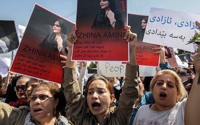 Des femmes scandant des slogans et brandissant des pancartes à l'effigie de Mahsa Amini, 22 ans, décédée alors qu'elle était détenue par les autorités iraniennes, lors d'une manifestation dénonçant sa mort organisée par des Kurdes irakiens et iraniens devant les bureaux des Nations unies à Arbil, capitale de la région autonome du Kurdistan irakien, le 24 septembre 2022. (Crédit : Safin Hamed/AFP)