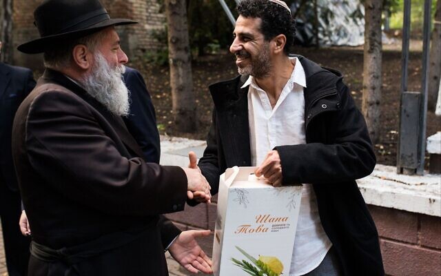 Le grand rabbin de Kiev, Jonathan Markovich, à gauche, remet un colis de Rosh Hashana à un membre de la communauté juive locale. (Crédit : Autorisation)