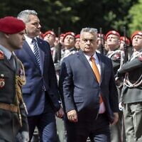 Le Premier ministre hongrois Viktor Orban (R) et le chancelier autrichien Karl Nehammer passent en revue une garde d'honneur devant la Chancellerie fédérale lors de la visite officielle d'Orban en Autriche à Vienne, le 28 juillet 2022. (Crédit : Alex Halada/AFP)