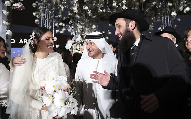 Un représentant du gouvernement émirati, au centre, félicite Lea Hadad, à gauche, et le rabbin Levi Duchman pour leur mariage, célèbre à Abu Dhabi, aux EAU, le 14 septembre 2022. (Crédit : Sami Sasso)