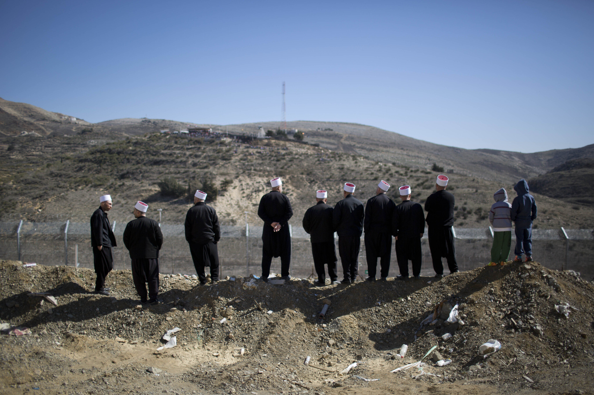 Des Druzes regardent au-delà de la frontière entre Israël et la Syrie, près de  Majdal Shams, sur le plateau du Golan, le 14 février 2014. (Crédit : AP/Oded Balilty)