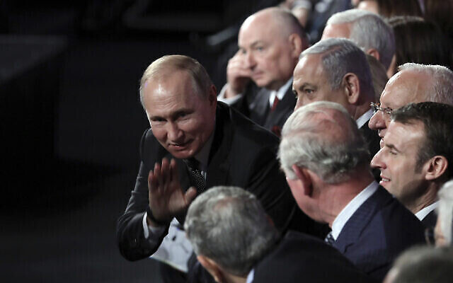 Le président russe Vladimir Poutine salue celui qui était alors le prince Charles d'Angleterre, lors du Forum mondial sur la Shoah, à Jérusalem, le 23 janvier 2020 (Crédit : Abir Sultan/Pool Photo via l'AP)