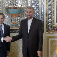 Le directeur général de l'AIEA, Rafael Mariano Grossi, à gauche, et le ministre iranien des Affaires étrangères Hossein Amirabdollahian se serrent la main avant leur réunion, à Téhéran, le 5 mars 2022. (Crédit : AP Photo)