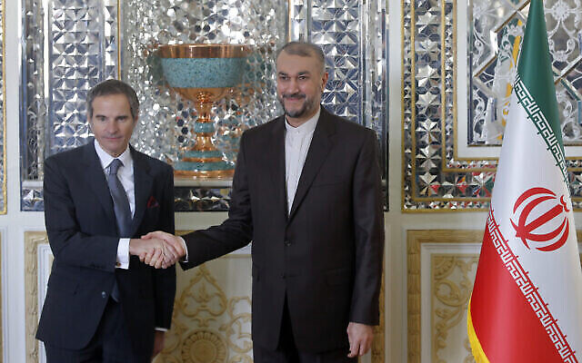 Le directeur général de l'AIEA, Rafael Mariano Grossi, à gauche, et le ministre iranien des Affaires étrangères Hossein Amirabdollahian se serrent la main avant leur réunion, à Téhéran, le 5 mars 2022. (Crédit : AP Photo)