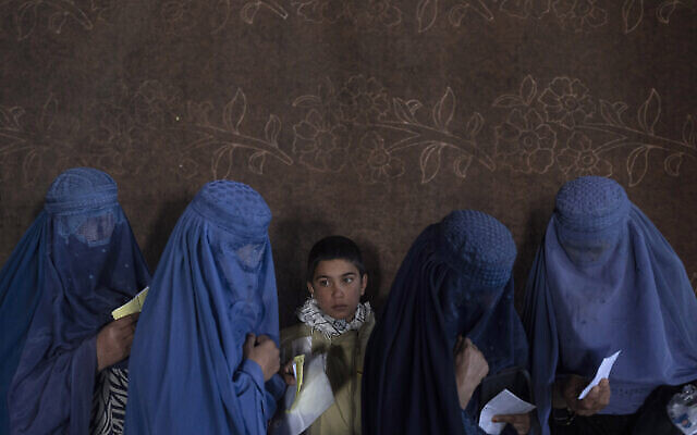 Des femmes afghanes attendent de recevoir de l'argent à un point de distribution d'argent organisé par le Programme alimentaire mondial, à Kaboul, en Afghanistan, le 20 novembre 2021 (Crédit : AP/Petros Giannakouris, File)