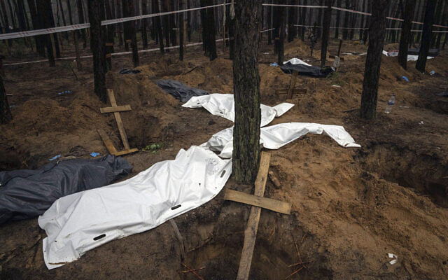 Des sacs contenant des cadavres sont vus pendant l'exhumation dans la zone récemment reprise d'Izioum, en Ukraine, vendredi 16 septembre 2022. (Crédit : AP Photo/Evgeniy Maloletka)