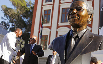 Le président sud-africain de l’époque, Jacob Zuma, deuxième à gauche, s’entretient avec Mandla Mandela, à gauche, après le dévoilement, en présence de nombreux dignitaires, d’un buste de l’ex-président sud-africain, Nelson Mandela, à droite, au Parlement sud-africain au Cap, en Afrique du Sud, le 28 avril 2014. (Crédit : AP Photo/Schalk van Zuydam)