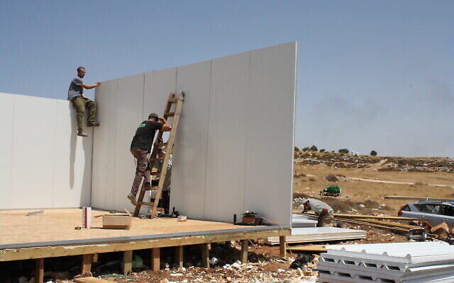 Des activistes reconstruisent l’une des structures de l’avant-poste de Ramat Migron, le 16 août 2022. (Crédit : Jeremy Sharon/Times of Israel)