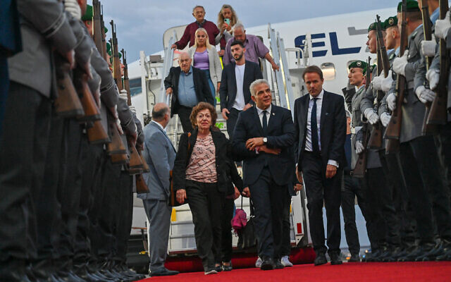Le Premier ministre Yair Lapid arrive à l'aéroport de Berlin accompagné de Shoshana Trister, une survivante de l'Holocauste née en Ukraine, le 11 septembre 2022. (Crédit : Kobi Gideon/GPO)