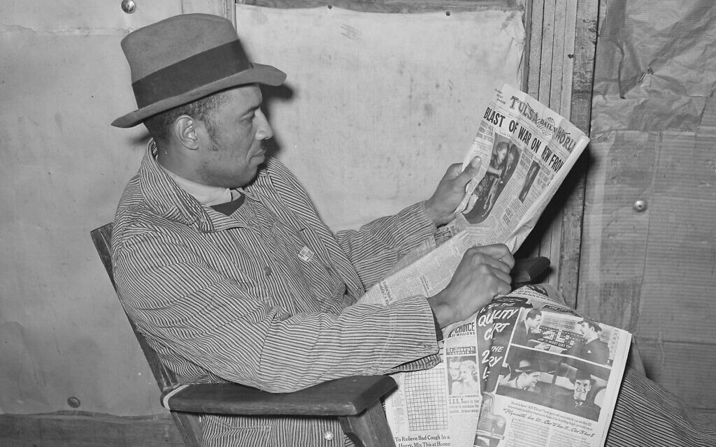 Un fermier américain lit le journal à  Creek County, dans l'Oklahoma, en février 1940. (Crédit : Bibliothèque du Congrès)