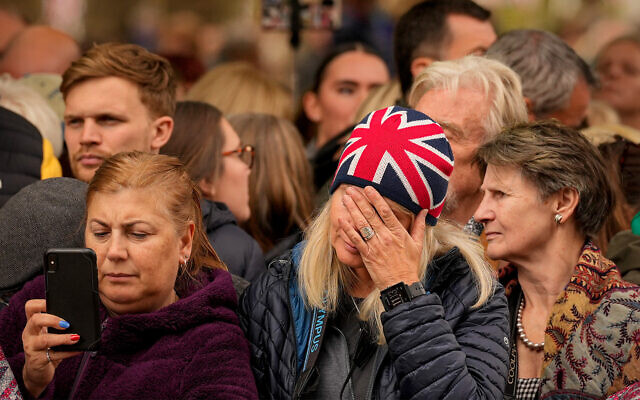 Des personnes en deuil pendant un moment de silence avant les funérailles de la reine Elizabeth II, dans le centre de Londres, le 19 septembre 2022. (Crédit : AP Photo/Andreea Alexandru/Pool)