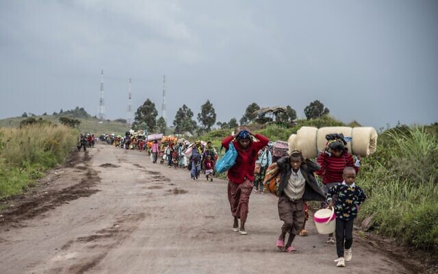 Des Congolais marchent sur la route de Kibumba, au nord de Goma, dans la république démocratique du Congo, pour fuir les combats entre les forces congolaises et les rebelles du M23 dans la province du Nord-Kivu, le 24 mai 2022. (Crédit : AP Photo/Moses Sawasawa)