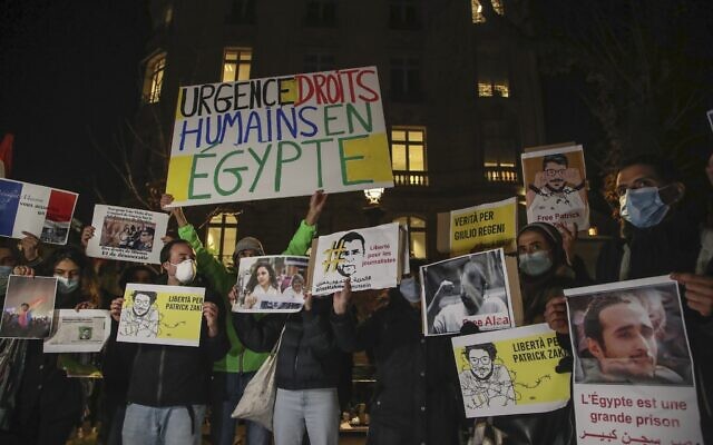 Des personnes tenant des pancartes lors d'une manifestation contre le président égyptien Abdel Fattah al-Sissi près de l'Assemblée nationale à Paris, le 8 décembre 2020. (Crédit : AP Photo/Michel Euler)