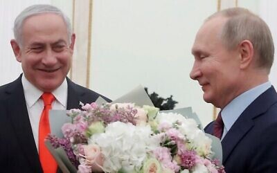 Le président russe Vladimir Poutine, à droite, avec un bouquet de fleurs et le Premier ministre de l'époque Benjamin Netanyahu, au Kremlin à Moscou, le 30 janvier 2020. (Crédit : Maxim Shemetov/Pool/AFP)