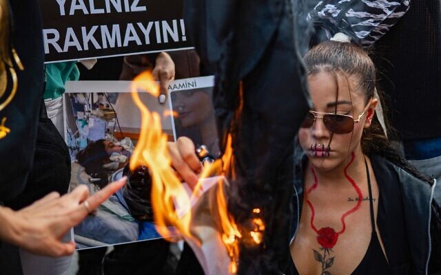 Des manifestantes aux abords du consulat iranien d'Istanbul protestent contre la mort de Mahsa Amini, arrêtée par la police des mœurs parce qu'elle contrevenait aux règles strictes du port du voile en Iran, à Istanbul, le 29 septembre 2022. (Crédit : Yasin AKGUL / AFP)