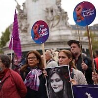 Des militants participent à une manifestation sur la place de la République à Paris, le 30 septembre 2022, pour soutenir les femmes iraniennes après la mort de Masha Amini, une Kurde iranienne de 22 ans. (Crédit : Thomas SAMSON / AFP)