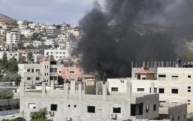 De la fumée lors d'une opération d'arrestation israélienne à Jénine, en Cisjordanie, le 8 octobre 2022. (Crédit : Jaafar Ashtiyeh/AFP)
