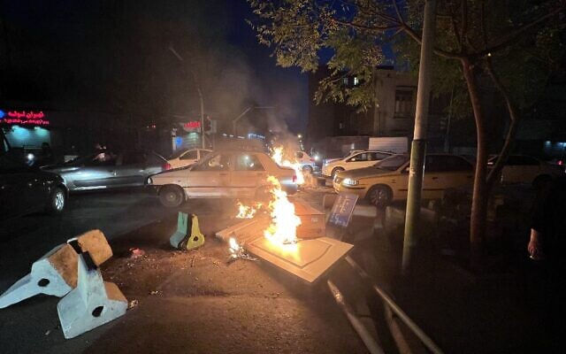 Des objets incendiés dans une rue de la capitale dans le cadre des manifestations géantes en Iran, à Téhéran, le 8 octobre 2022. (Crédit : Photo obtenue par l'AFP hors de l'Iran)