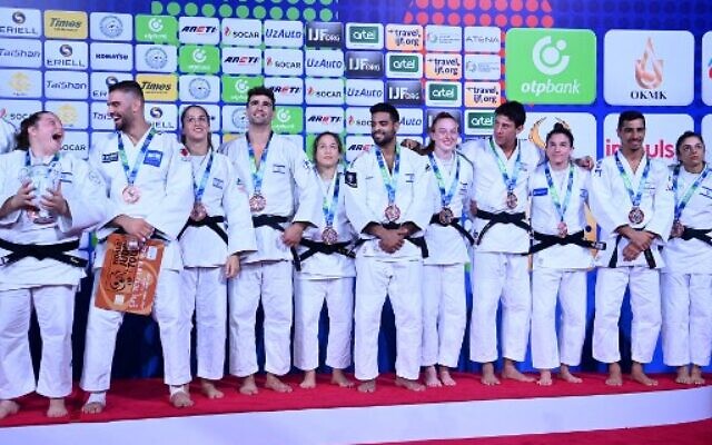 L'équipe d'Israël, médaillée de bronze, lors de la cérémonie de remise des médailles de l'épreuve des équipes mixtes des Championnats du monde de judo 2022 à la Humo Arena de Tachkent, le 13 octobre 2022. (Crédit : Kirill Kudryavtsev/AFP)
