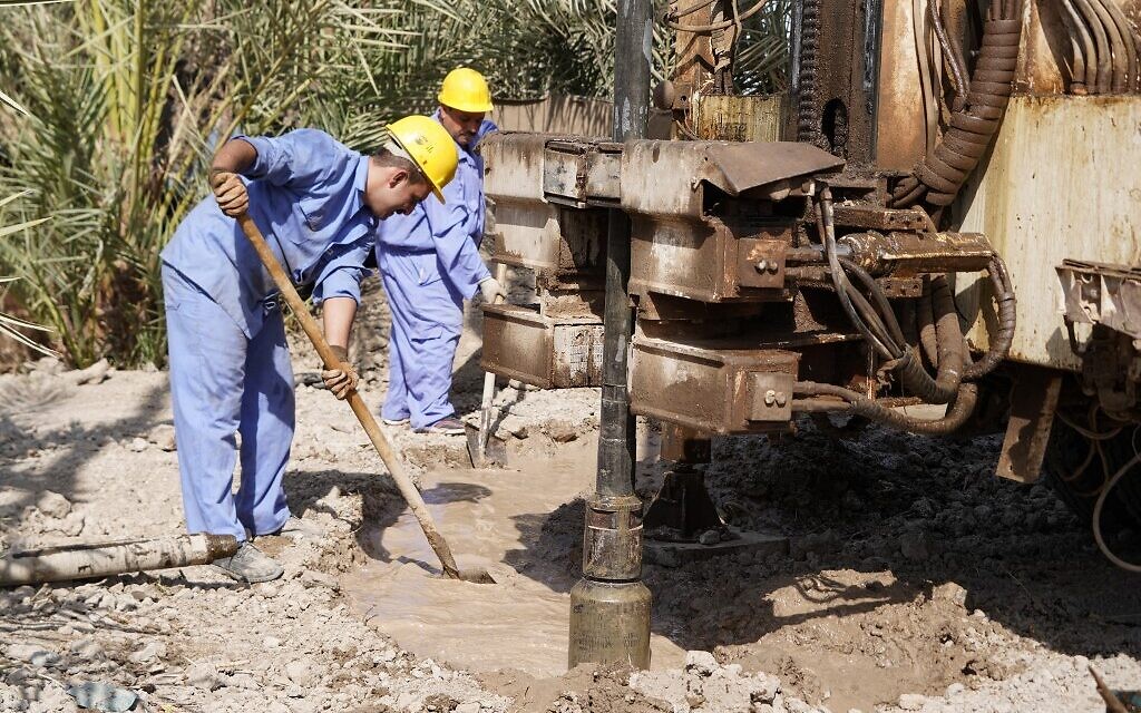 Des hommes creusent un puits dans le désert, aux abords de Najaf, dans le centre du pays, le 10 octobre 2022. (Crédit : Qassem al-KAABI / AFP)