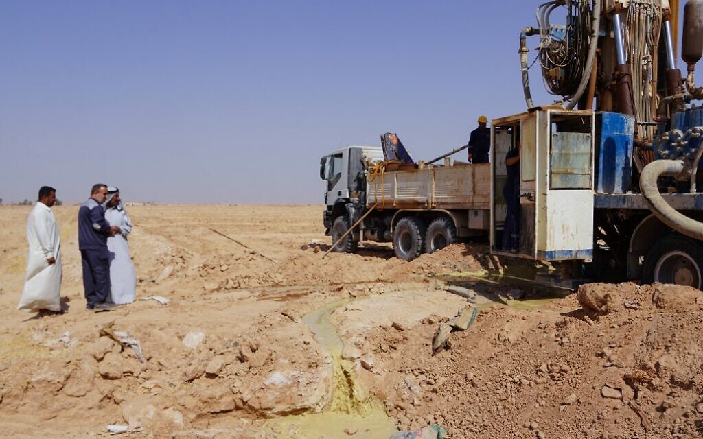 Le gestionnaire irakien des ressources hydrauliques Jamil al-Assadi, au centre, supervise le site où un puits va être creusé aux abords  aux abords de Najaf, dans le centre du pays, le 10 octobre 2022. (Crédit :  Qassem al-KAABI / AFP)