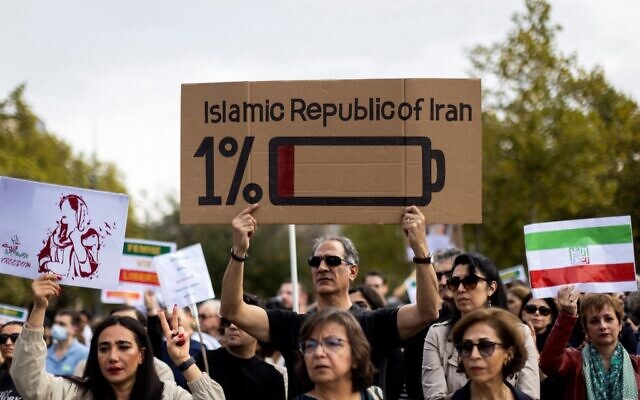 Des manifestants tiennent des pancartes lors d'un rassemblement de soutien aux manifestants en Iran, place de la République à Paris, le 29 octobre 2022. (Crédit : MOHAMMADREZA DEHDARI / agence de presse Isna / AFP)