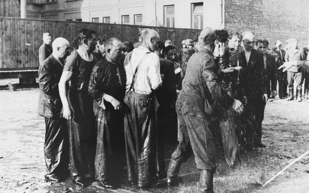 Des hommes juifs torturés avec des tuyaux d'arrosage avant leur meurtre public à Kaunas, en Lituanie, en juin 1941. (Crédit : Domaine public)