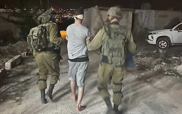 Des soldats de Tsahal arrêtent le Palestinien soupçonné d'avoir poignardé un Israélien dans le village d'al-Funduq en Cisjordanie, le 25 octobre 2022. (Crédit : armée israélienne)