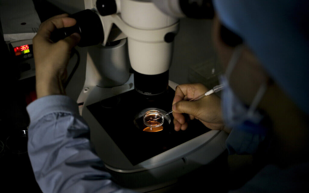 Un membre du personnel médical recueillant un ovule sur un plat de laboratoire lors d'un traitement de l'infertilité par fécondation in vitro (FIV) pour un patient dans un hôpital de Pékin, le 24 avril 2016. (Crédit : AP Photo/Andy Wong)