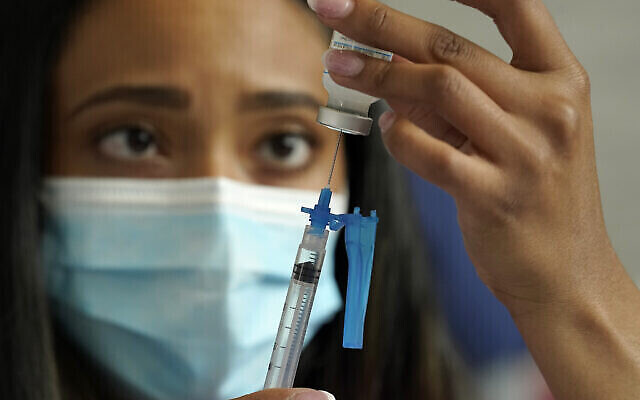 Sur cette photo du 19 mai 2021, on voit  une infirmière se préparer à administrer un vaccin contre la COVID-19 de Moderna, dans un centre de vaccination installé au stade Gillette de Foxborough, dans le Massachusetts. (Crédit : AP Photo/Steven Senne)
