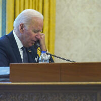 Le président américain Joe Biden parlant au téléphone depuis le bureau ovale de la Maison Blanche à Washington, le 9 décembre 2021. (Crédit : AP Photo/Susan Walsh)