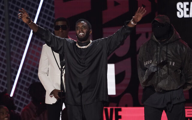 Sean "Diddy" Combs acceptant le prix pour l'ensemble de sa carrière lors des BET Awards ; Babyface et Kanye West à l'arrière gauche, au Microsoft Theater, à Los Angeles, le 26 juin 2022. (AP Photo/Chris Pizzello)